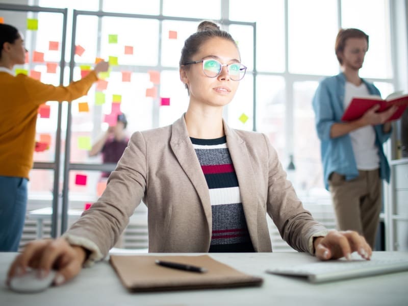 Seo-Process-Step-By-Step-Comprehensive-Guide A woman in the office working at a computer looking straight ahead