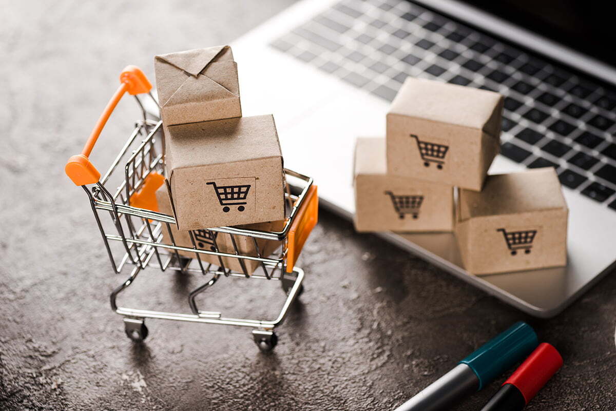 Selective focus of toy shopping cart with small carton boxes nea