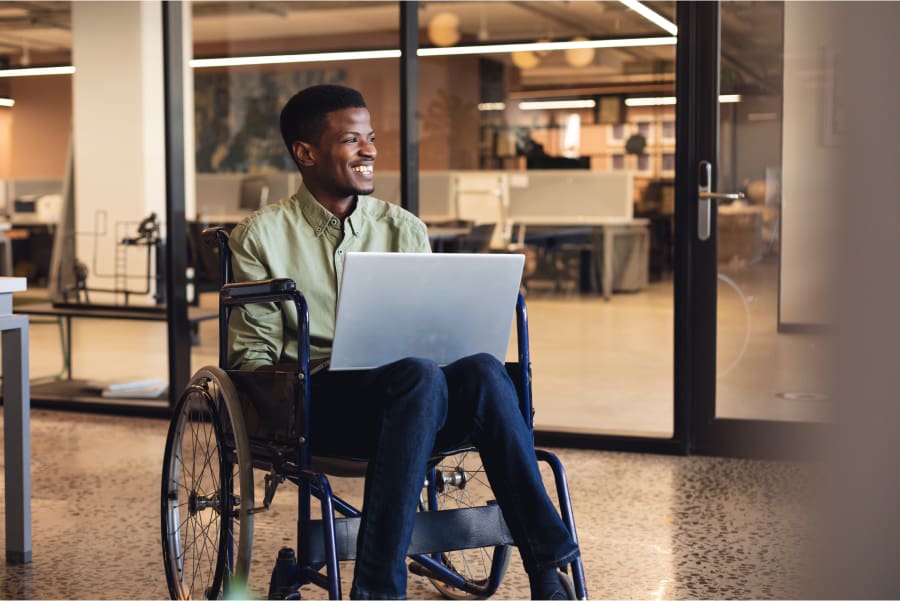 Disabled-Man-Smiling-While-Working-On-His-Laptop Disabled man smiling while working on his laptop