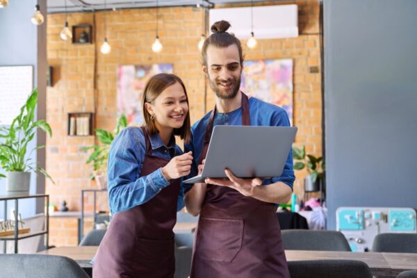 Owners-Updating-Google-My-Business Business owner comparing seo pricing proposals on a laptop and paper documents